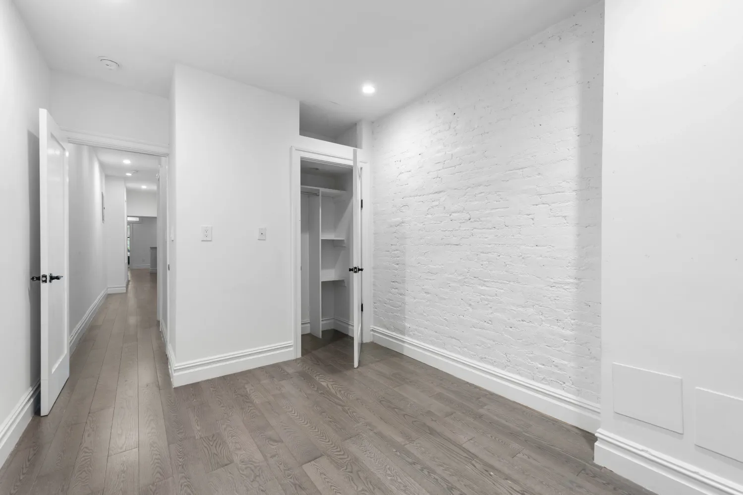a view of a hallway with wooden floor