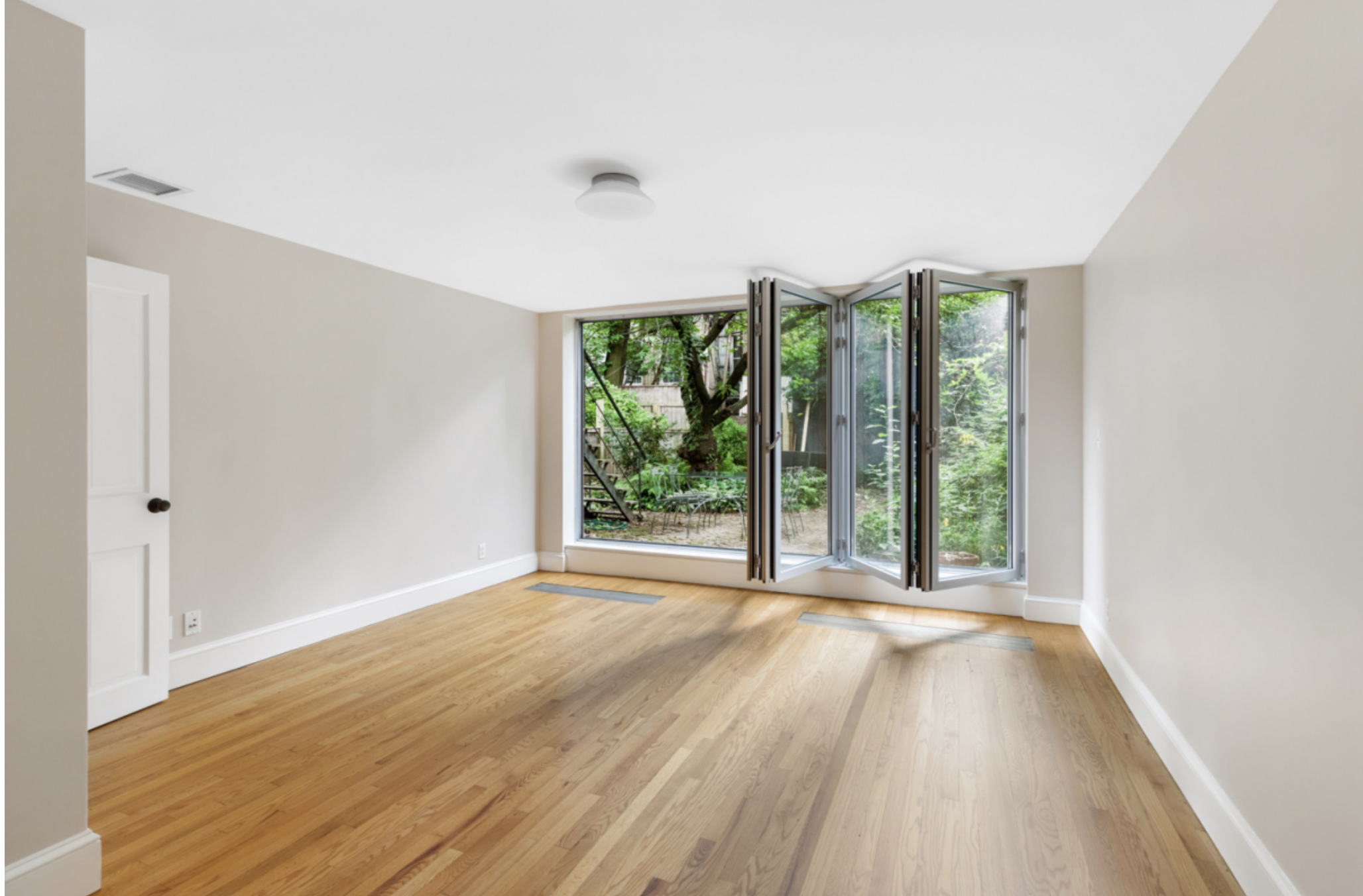 128 State Street, Unit GARDEN Brooklyn, NY 11201 - Photo 7 of 10 a view of an empty room with wooden floor and glass door