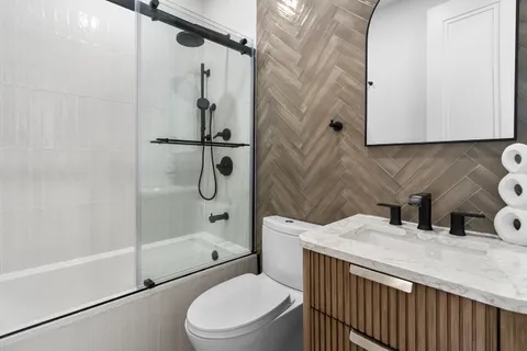 a bathroom with a sink a toilet and shower