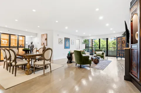 a living room with furniture flat screen tv and a large window