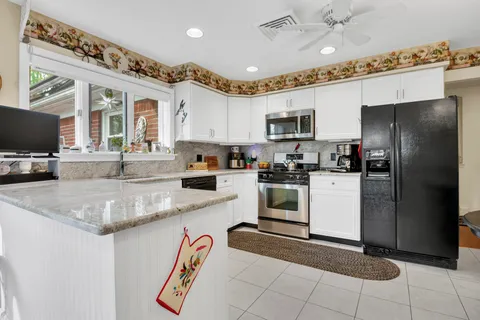 a kitchen with a refrigerator a sink and a stove top oven