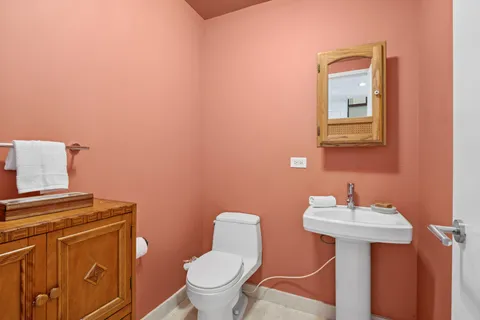 a bathroom with a toilet a sink and mirror