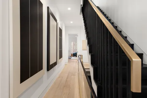 a view of a hallway with wooden floor and staircase