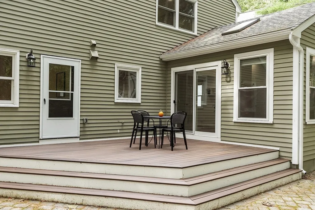 a view of house with deck and furniture