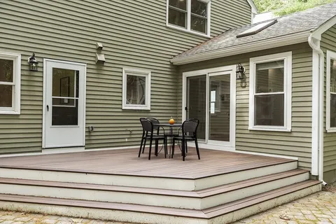 a view of house with deck and furniture