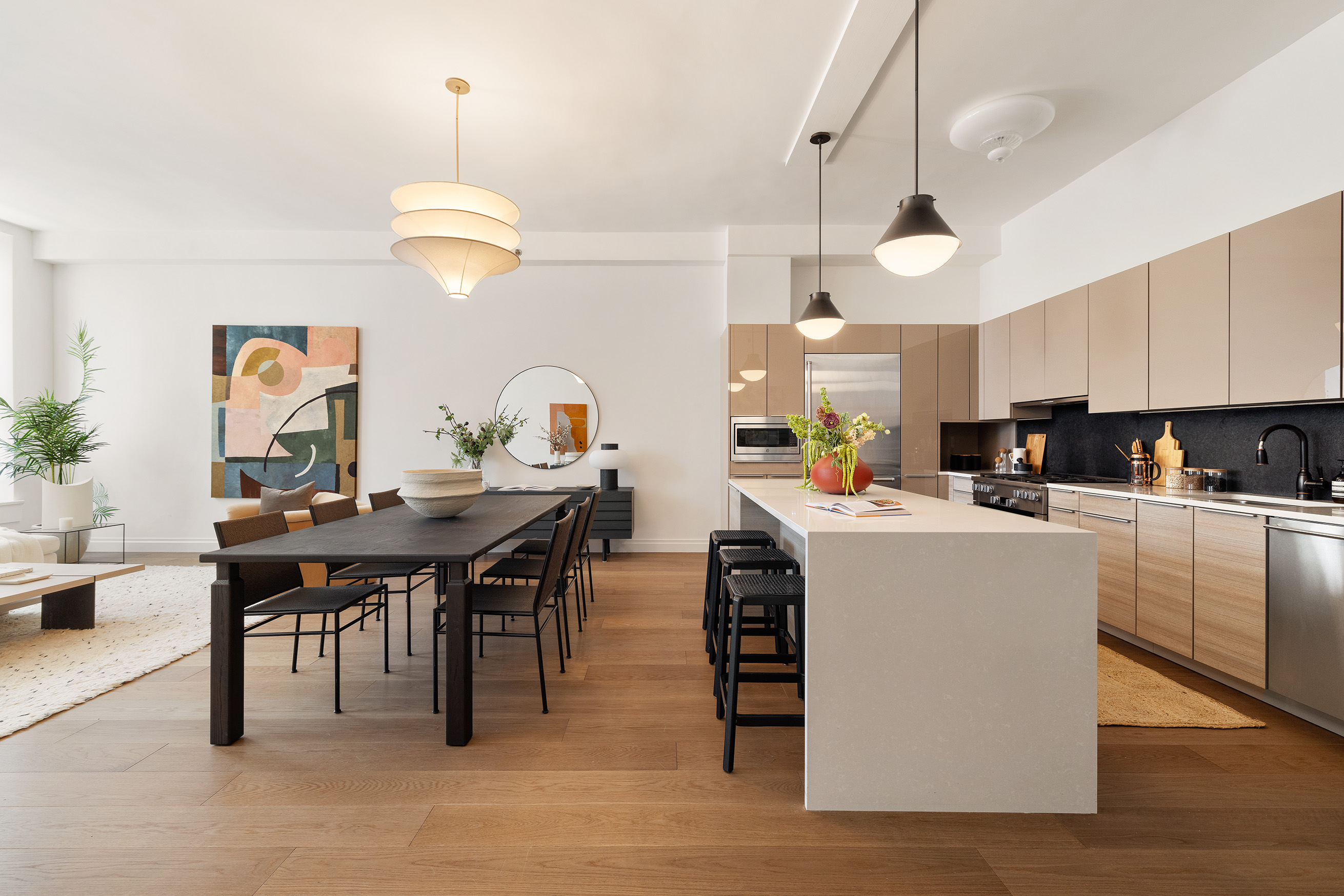 42 East 20th Street, Unit 4AD Manhattan, NY 10003 - Photo 3 of 19 a kitchen with stainless steel appliances kitchen island granite countertop a table chairs and a refrigerator