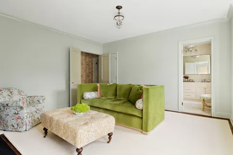 a living room with a bed and dresser