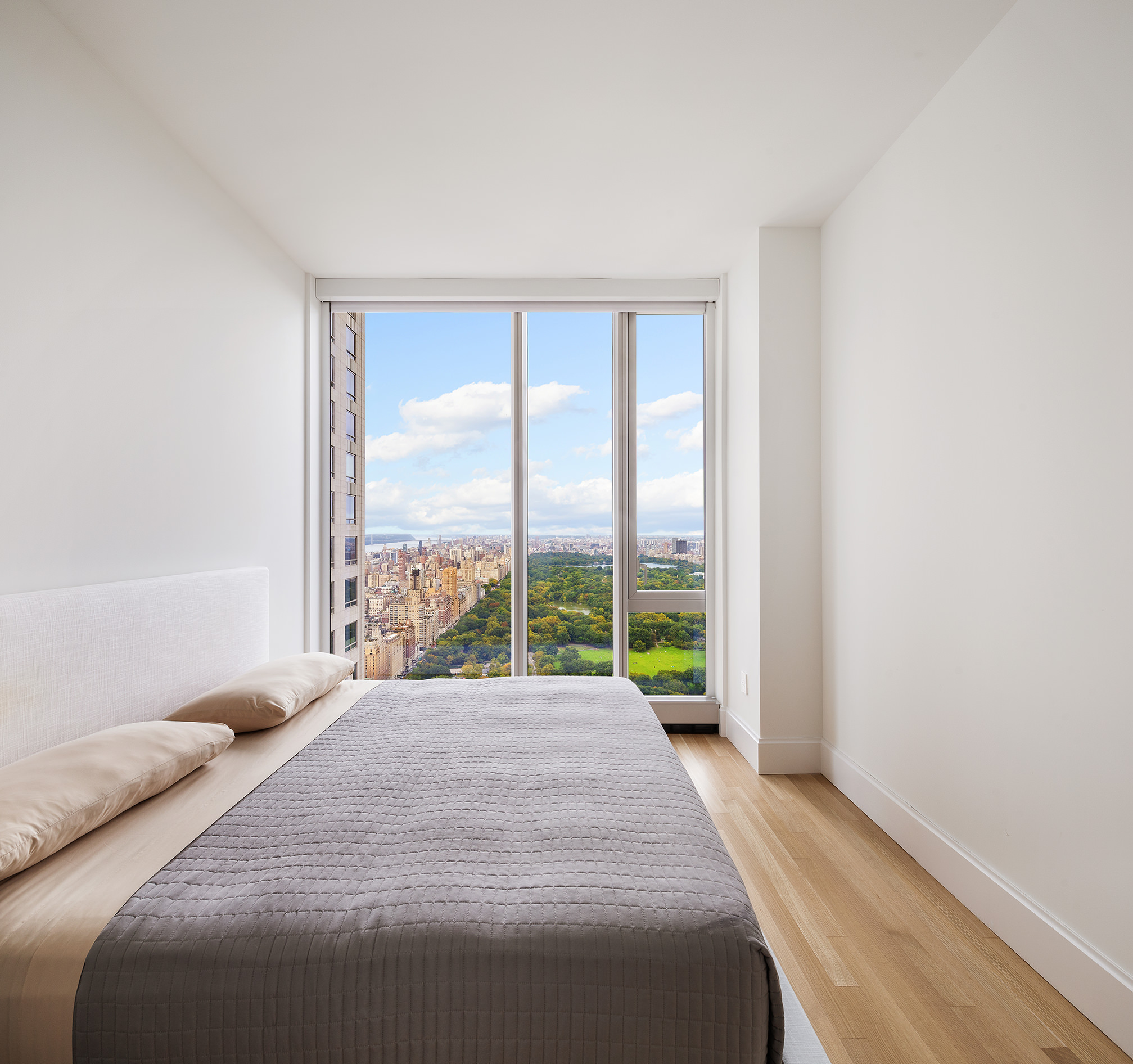 217 West 57th Street, Unit 57N Manhattan, NY 10019 - Photo 3 of 10 a bedroom with a large bed and a large window