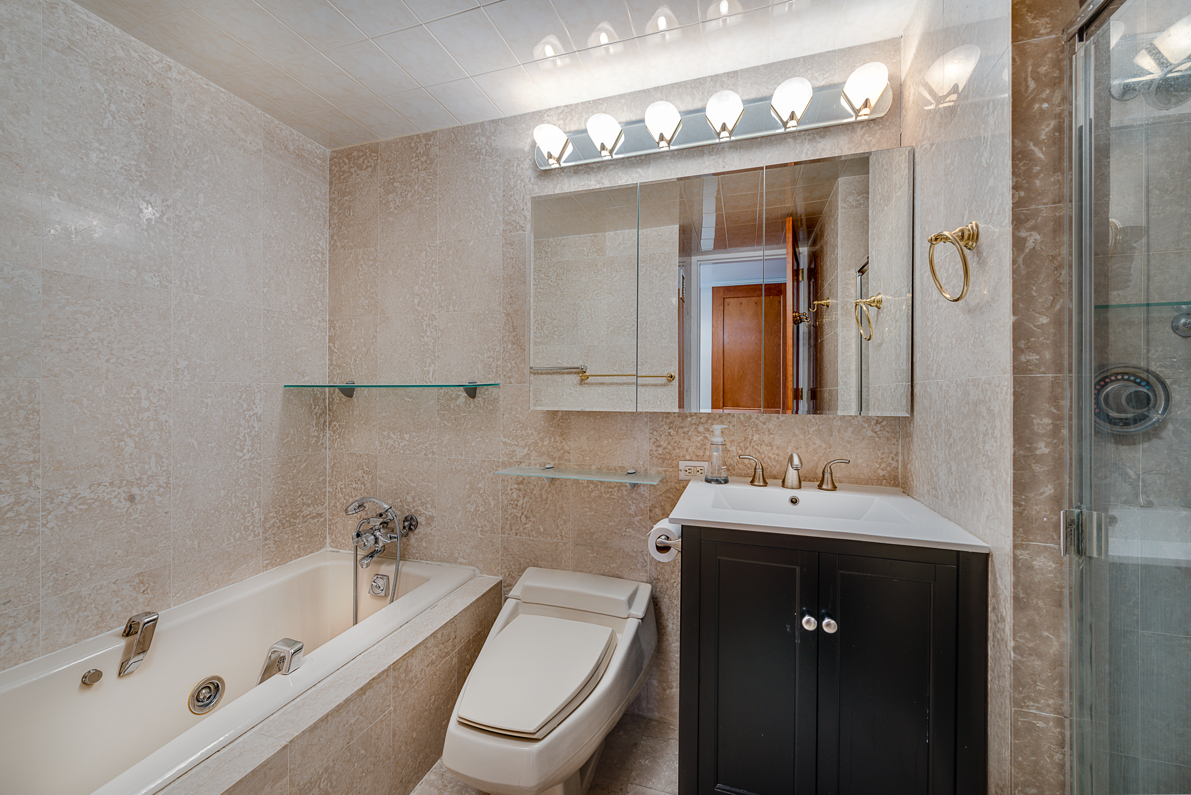 160 West 66th Street, Unit 23D Manhattan, NY 10023 - Photo 5 of 10 a bathroom with a toilet a sink a tub and mirror