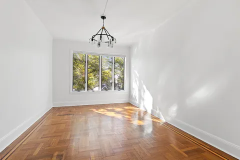 a view of a hallway with a window and a chandelier