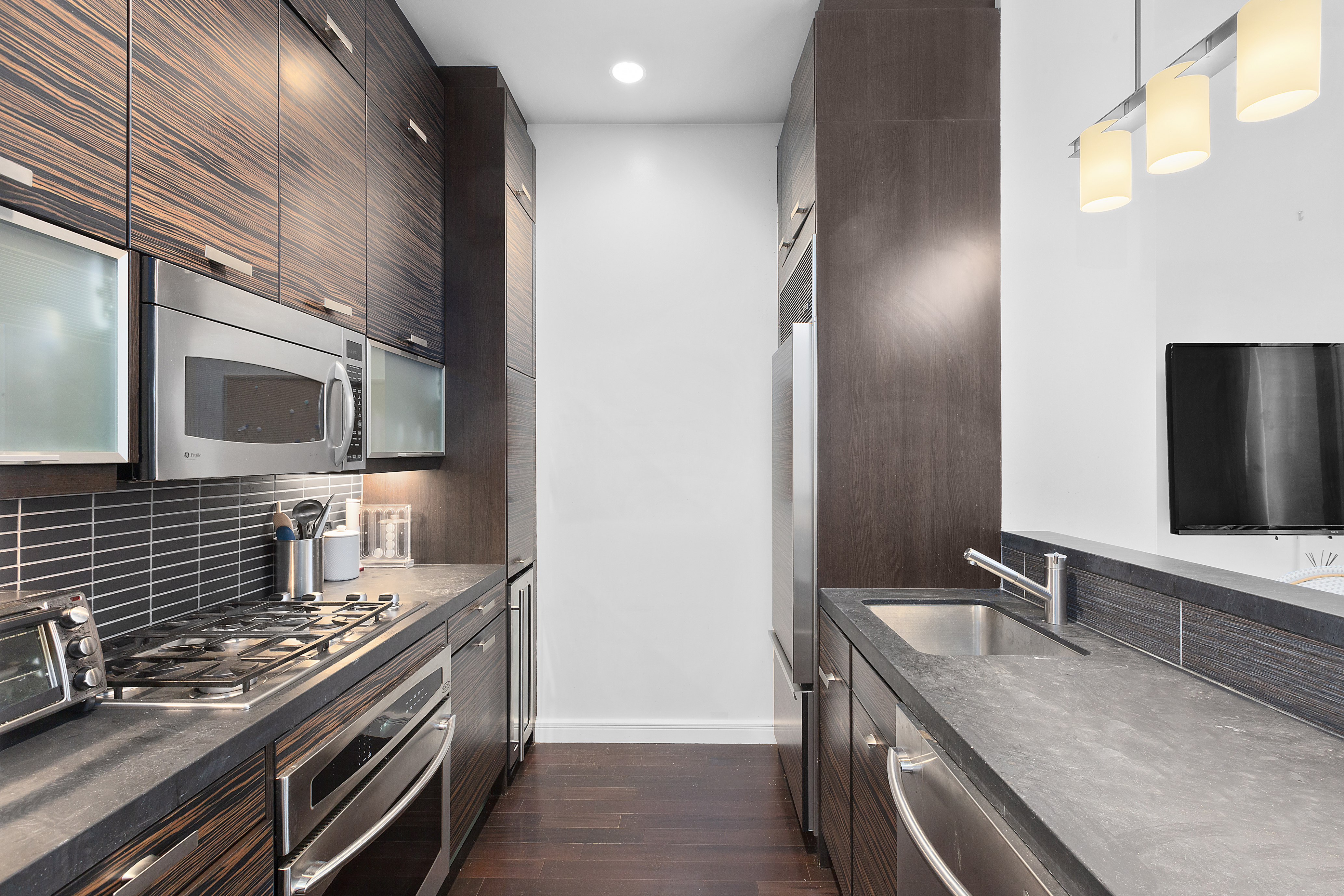 101 West 24th Street, Unit 4G Manhattan, NY 10011 - Photo 2 of 7 a kitchen with stainless steel appliances granite countertop a sink and a stove