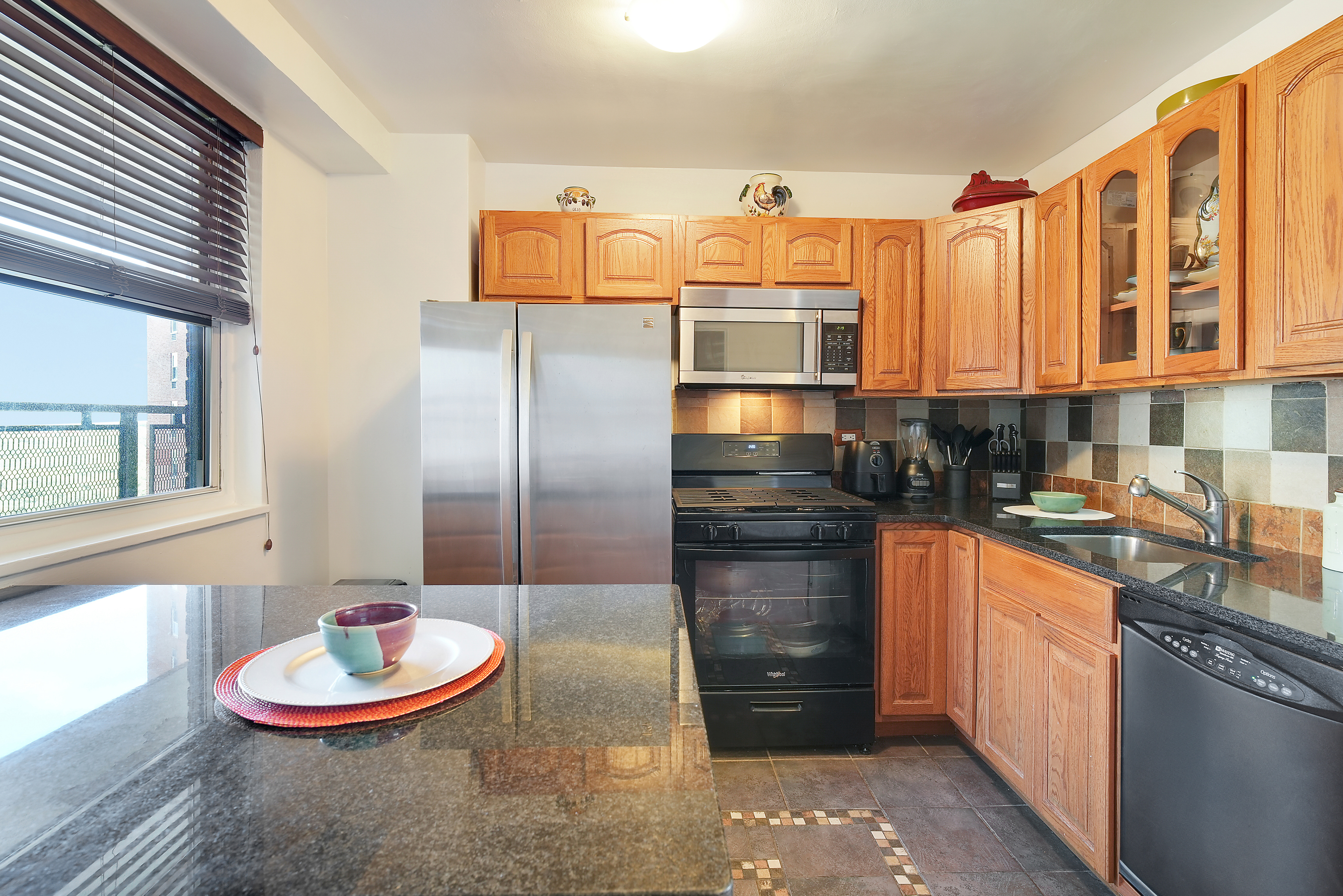 5700 Arlington Avenue, Unit 16T Bronx, NY 10471 - Photo 6 of 16 a kitchen with stainless steel appliances granite countertop a sink a stove and a refrigerator