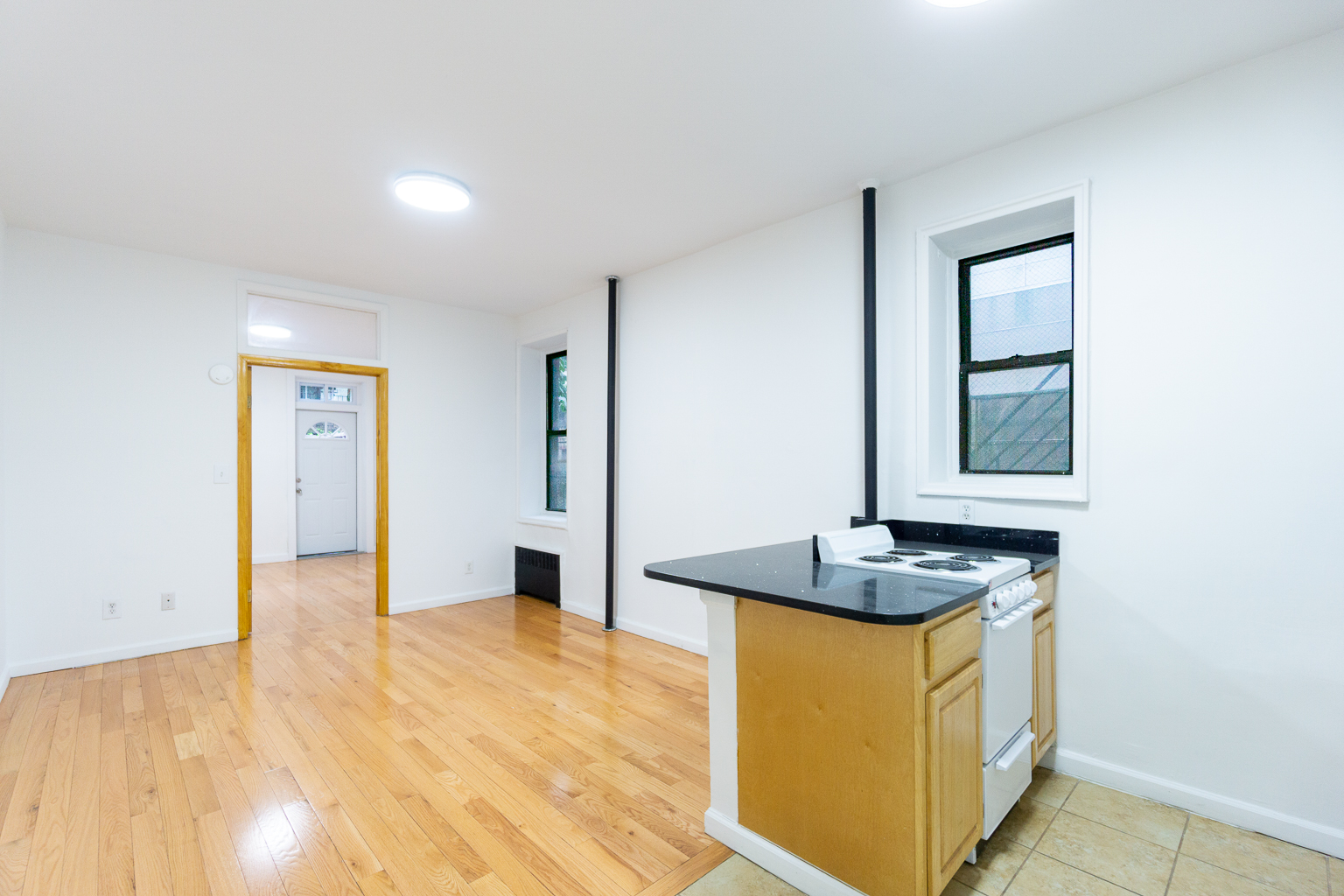 315 East 5th Street, Unit 1C Manhattan, NY 10003 - Photo 10 of 15 a kitchen with granite countertop cabinets and window