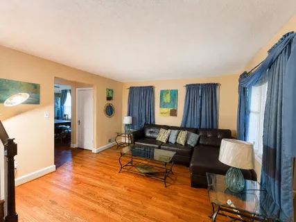 a living room with furniture and a wooden floor