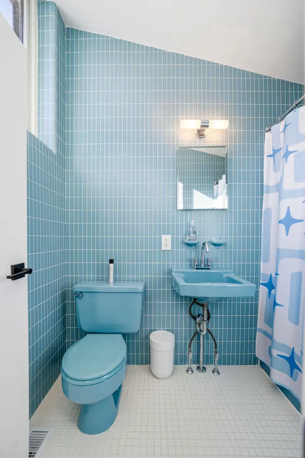 a bathroom with a toilet a sink and mirror