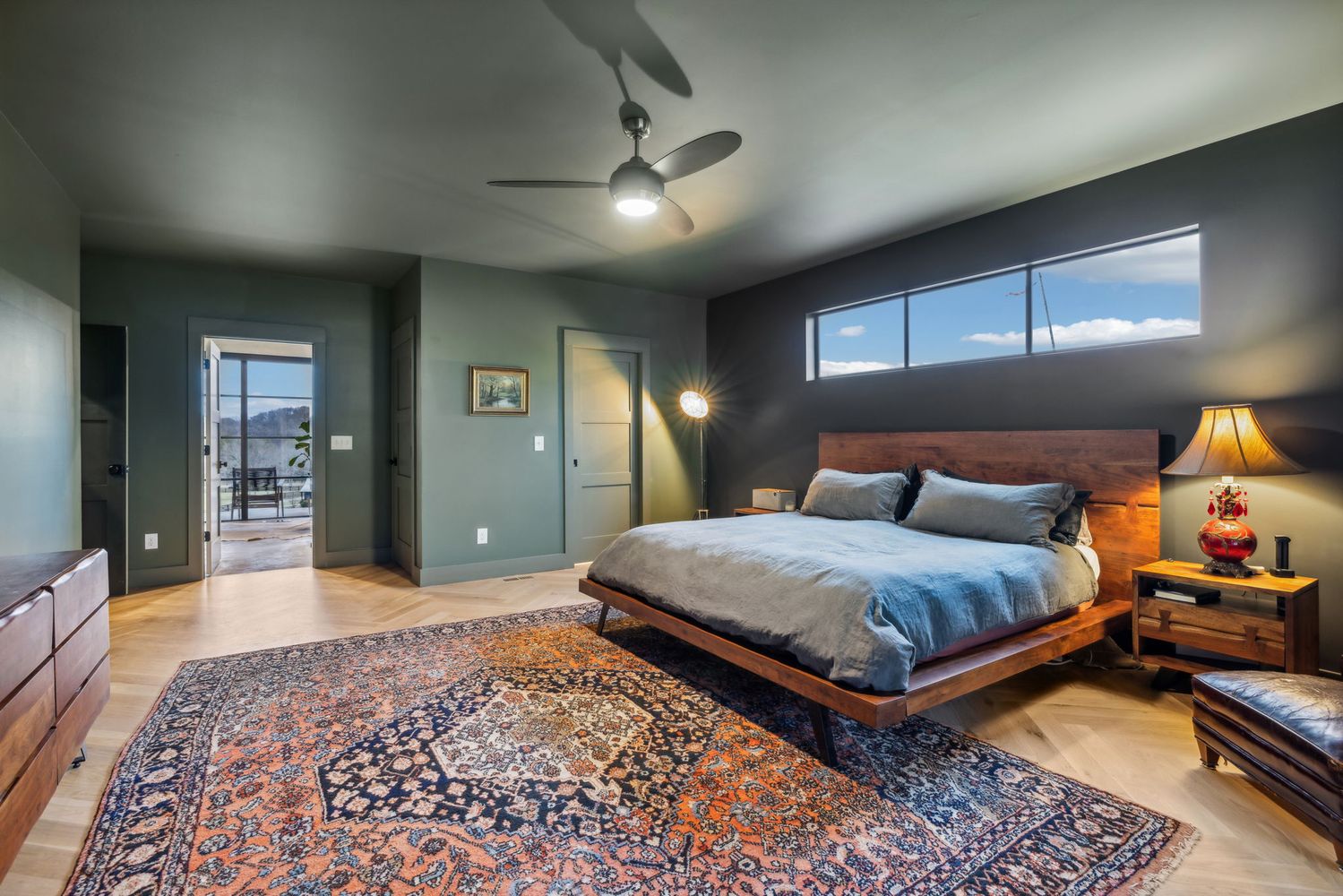 a spacious bedroom with a bed and a dresser in it