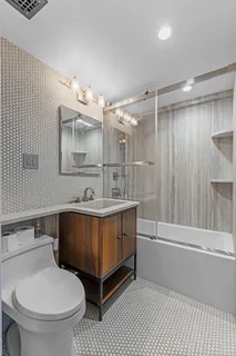 a bathroom with a sink a toilet and shower
