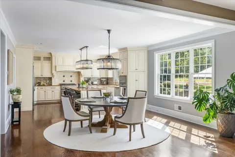 a dining room with furniture a chandelier and wooden floor