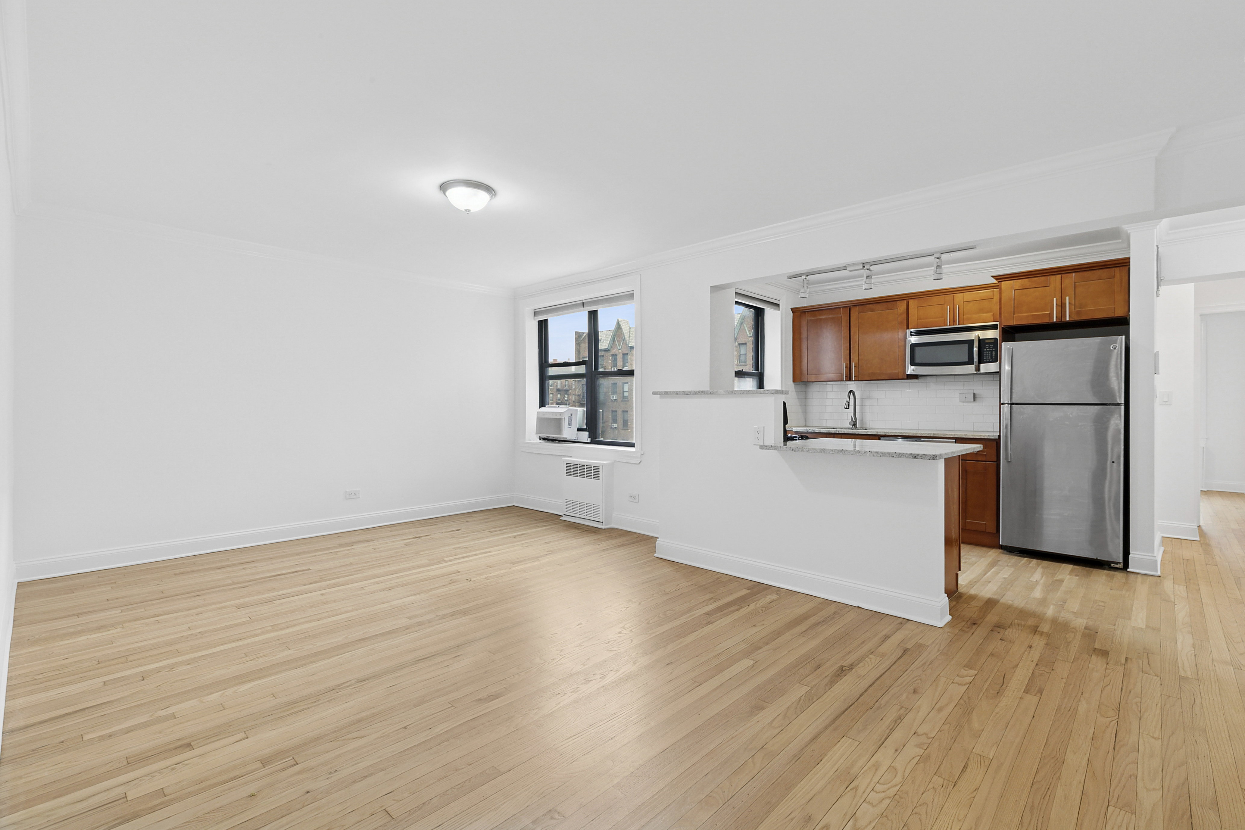 4501 Broadway, Unit 4G Manhattan, NY 10040 - Photo 3 of 7 a view of a kitchen with wooden floor and a hallway