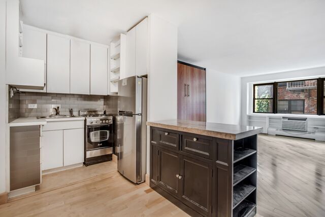 320 East 54th Street, Unit 4A Manhattan, NY 10022 - Photo 2 of 5 a kitchen with a sink stove and cabinets