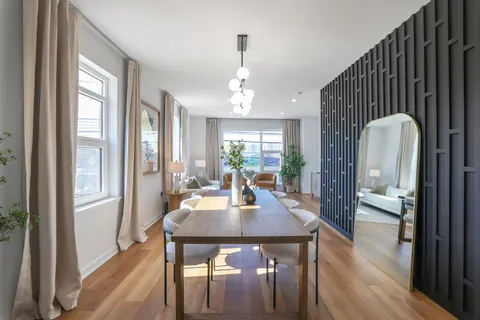 a dining room with wooden floor a glass table and chairs