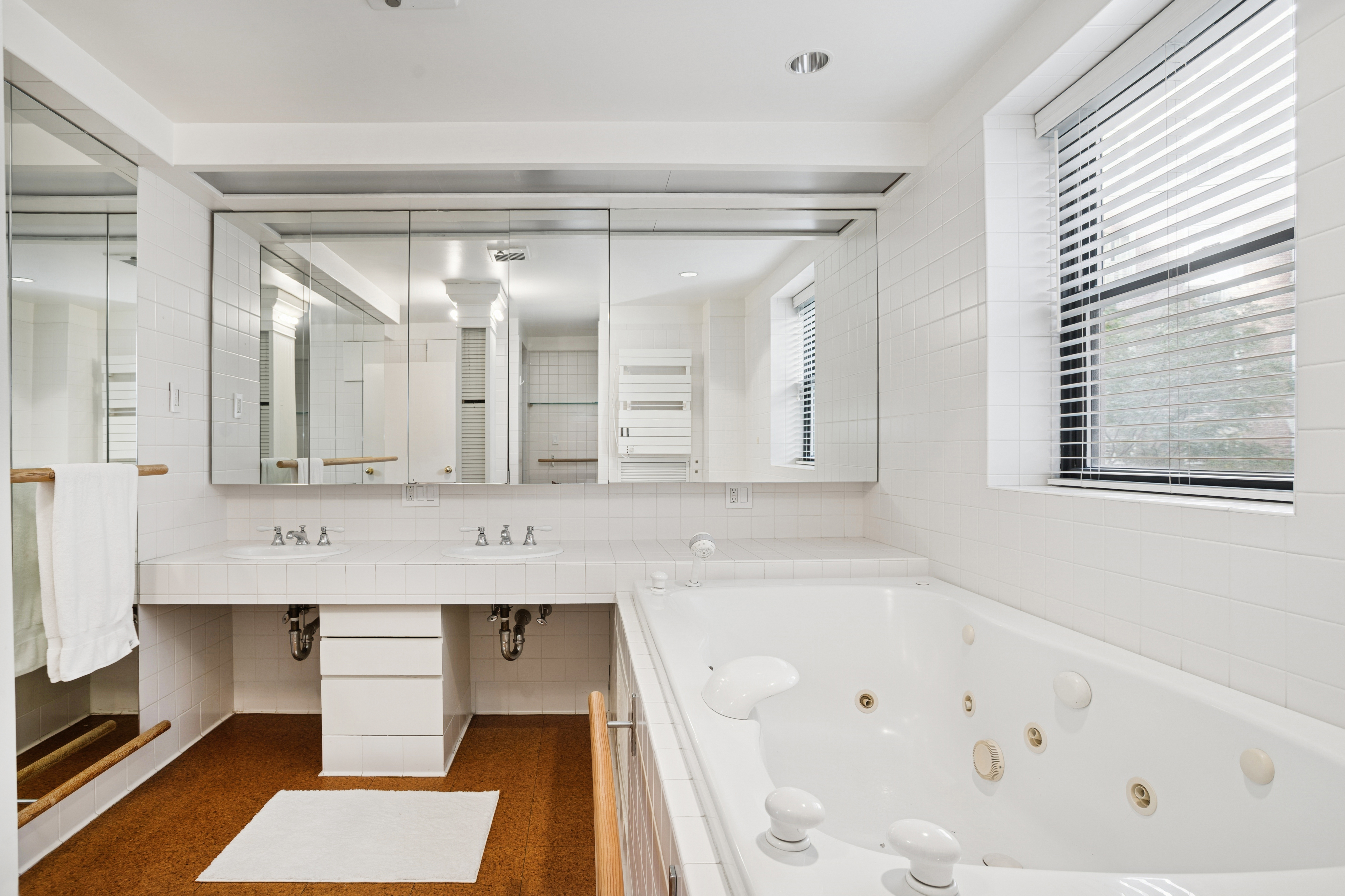 440 East 56th Street, Unit 6FGH Manhattan, NY 10022 - Photo 9 of 18 a bathroom with a tub a sink and a large mirror