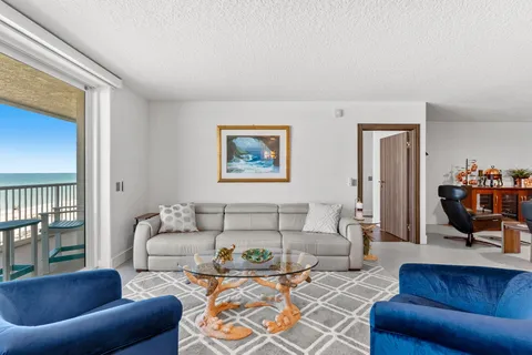 a living room with furniture a rug and a view of kitchen