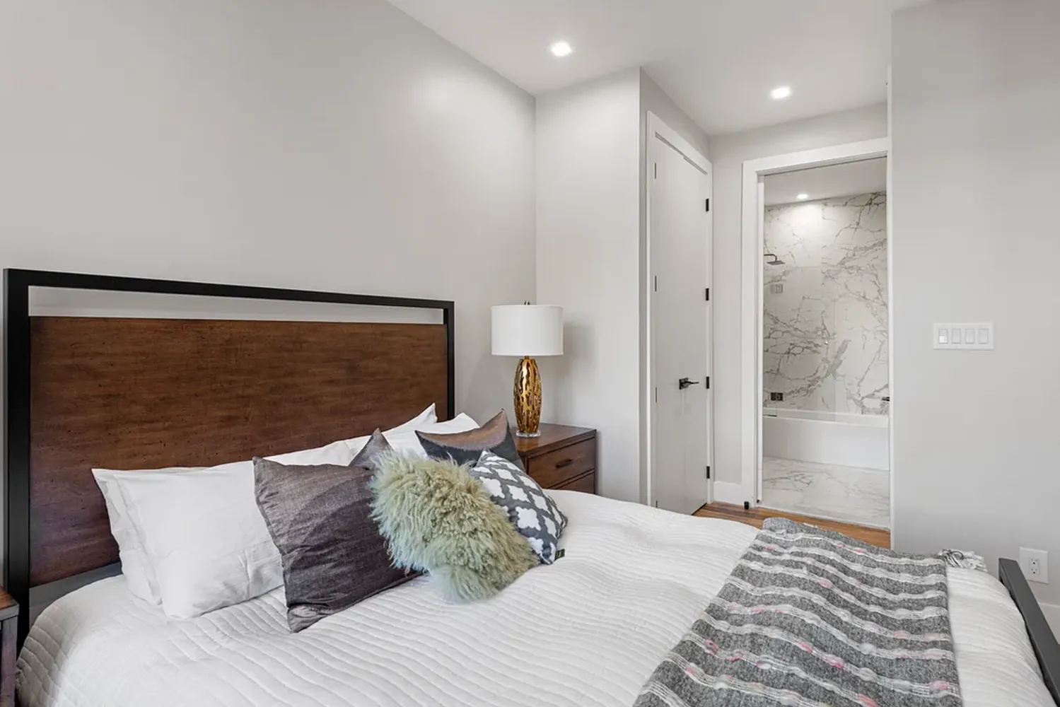 a bedroom with a large bed and a chandelier