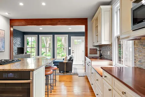 a large kitchen with stainless steel appliances granite countertop a stove a sink and a microwave