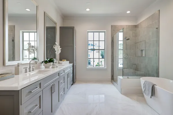 a spacious bathroom with a granite countertop tub sink a shower and a mirror