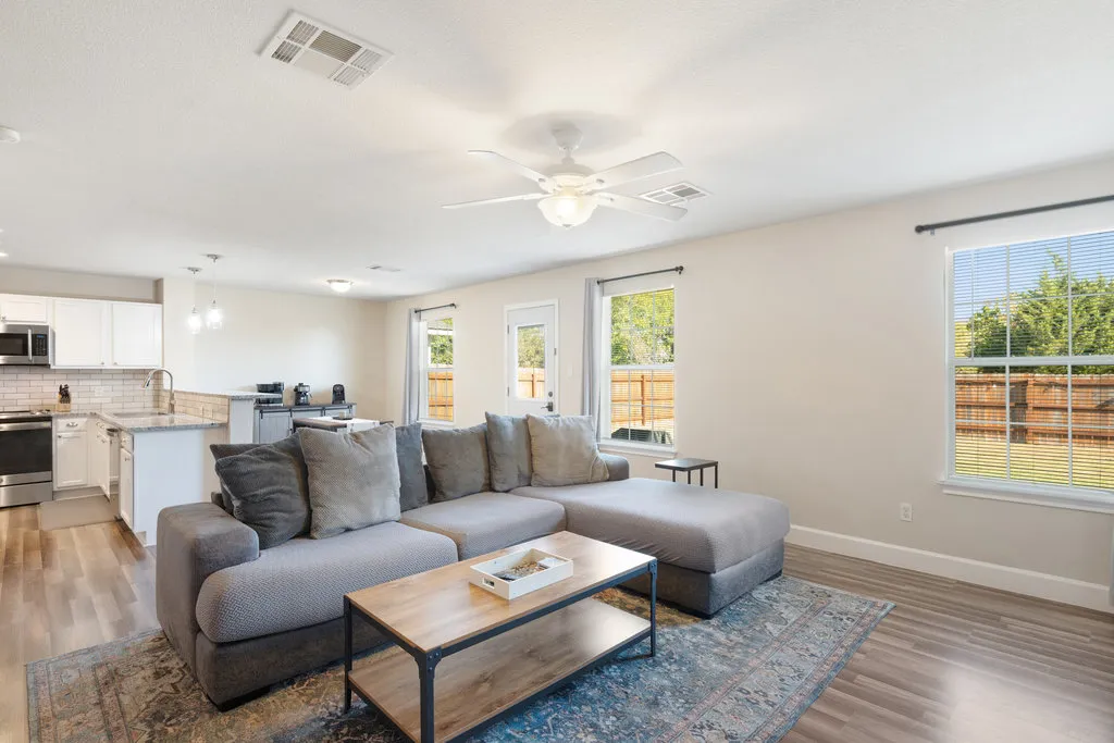 a living room with furniture and wooden floor