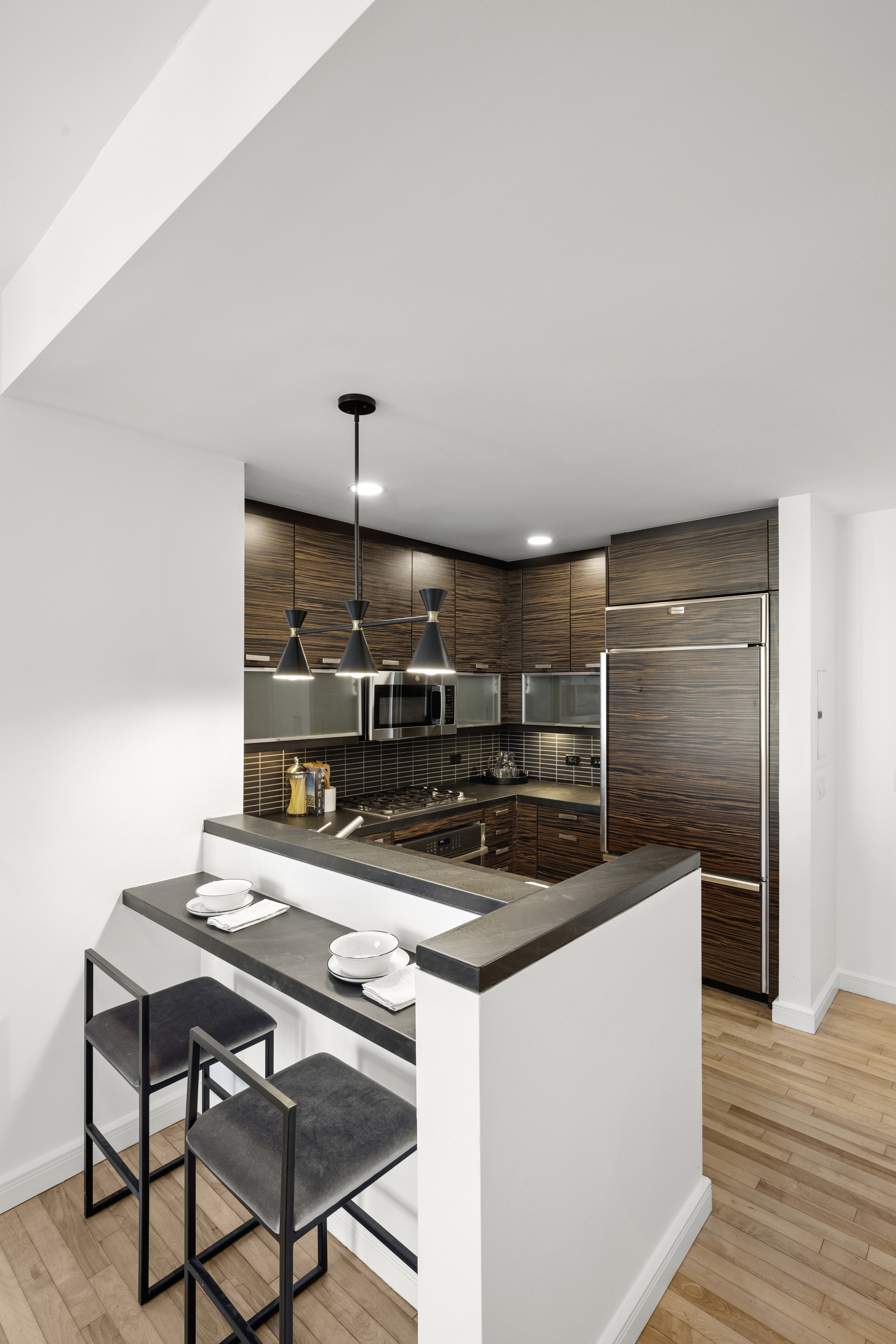 101 West 24th Street, Unit 23E Manhattan, NY 10011 - Photo 6 of 23 a kitchen with kitchen island a stove and a refrigerator