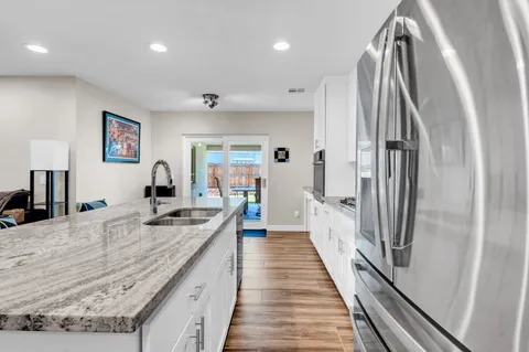 a large kitchen with kitchen island a counter top space a sink and stainless steel appliances
