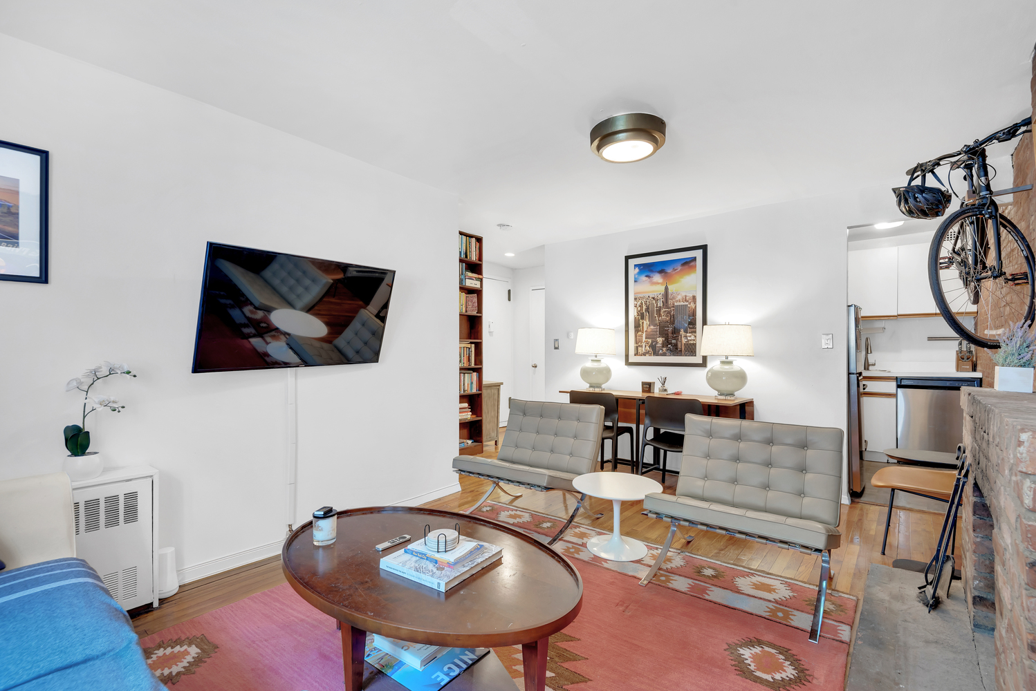 220 West 15th Street, Unit 1A Manhattan, NY 10011 - Photo 2 of 6 a living room with furniture a flat screen tv and a table