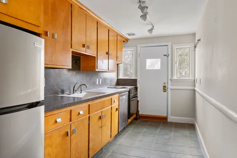 a kitchen with stainless steel appliances granite countertop a sink a stove and a refrigerator