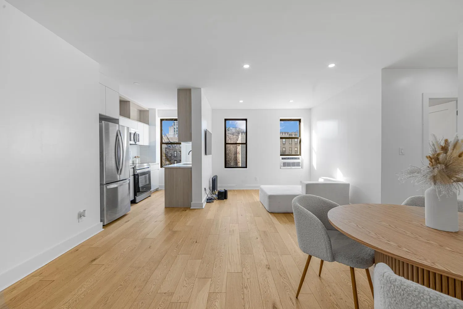 a kitchen with stainless steel appliances a dining table chairs and refrigerator