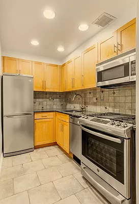 55 West 83rd Street, Unit GARDEN Manhattan, NY 10024 - Photo 3 of 6 a kitchen with stainless steel appliances granite countertop a stove a sink and a refrigerator