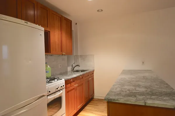 a kitchen with stainless steel appliances granite countertop a refrigerator and a stove