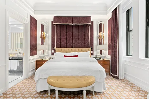 a bed sitting in a bedroom next to a window