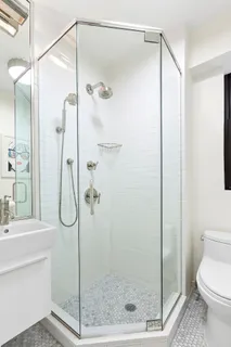 a bathroom with a shower and a sink a mirror