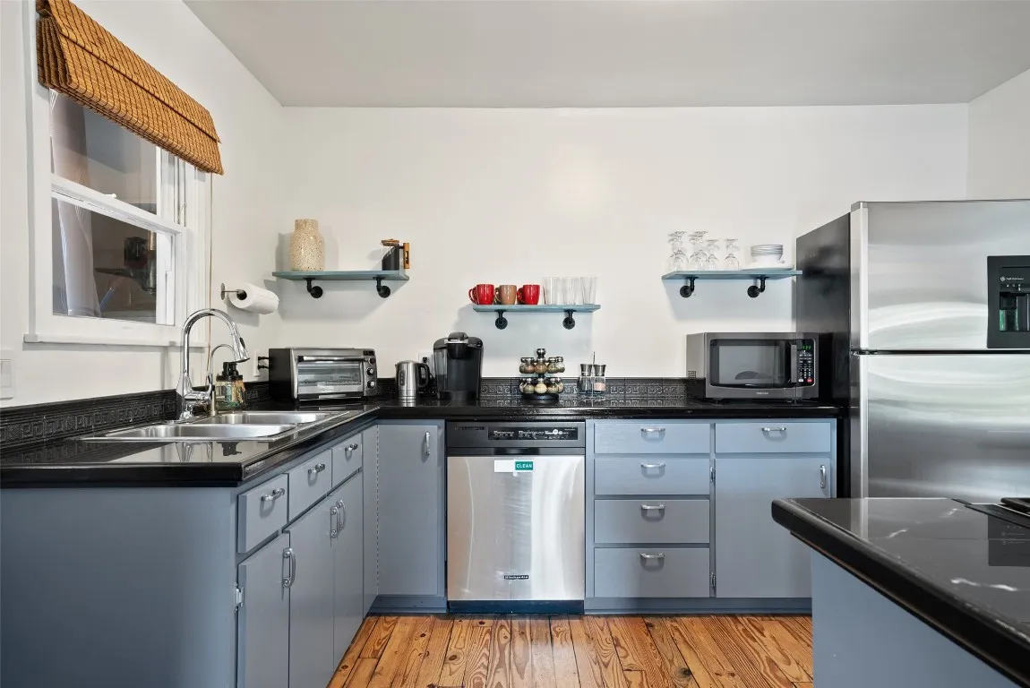 a kitchen with granite countertop a sink stainless steel appliances and cabinets