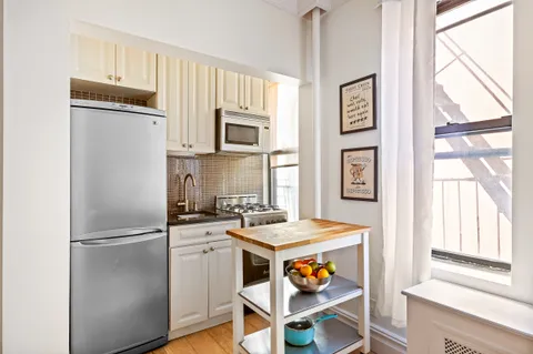 a kitchen with stainless steel appliances granite countertop a refrigerator and a stove top oven