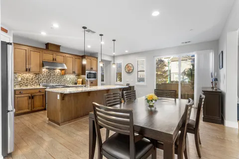 a kitchen with stainless steel appliances kitchen island granite countertop a refrigerator and a stove top oven