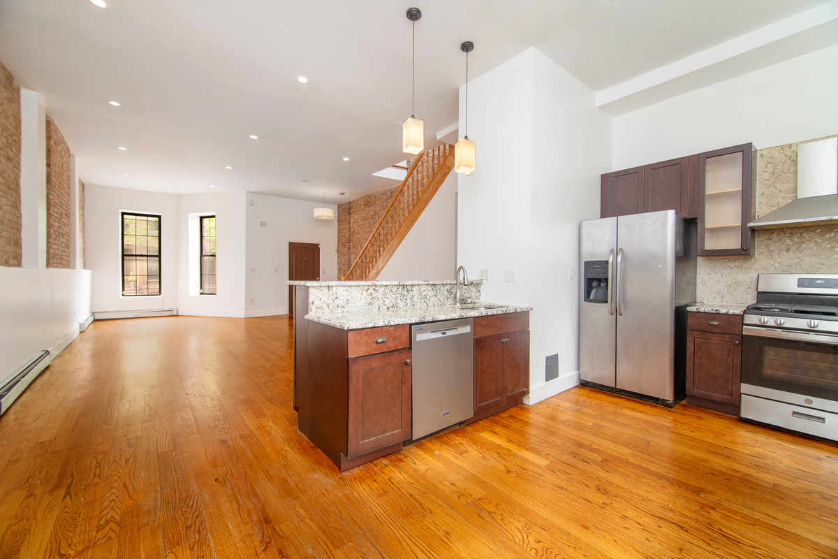 900 Lafayette Avenue Brooklyn, NY 11221 - Photo 2 of 13 a large kitchen with stainless steel appliances granite countertop a large counter top a stove and a wooden floors