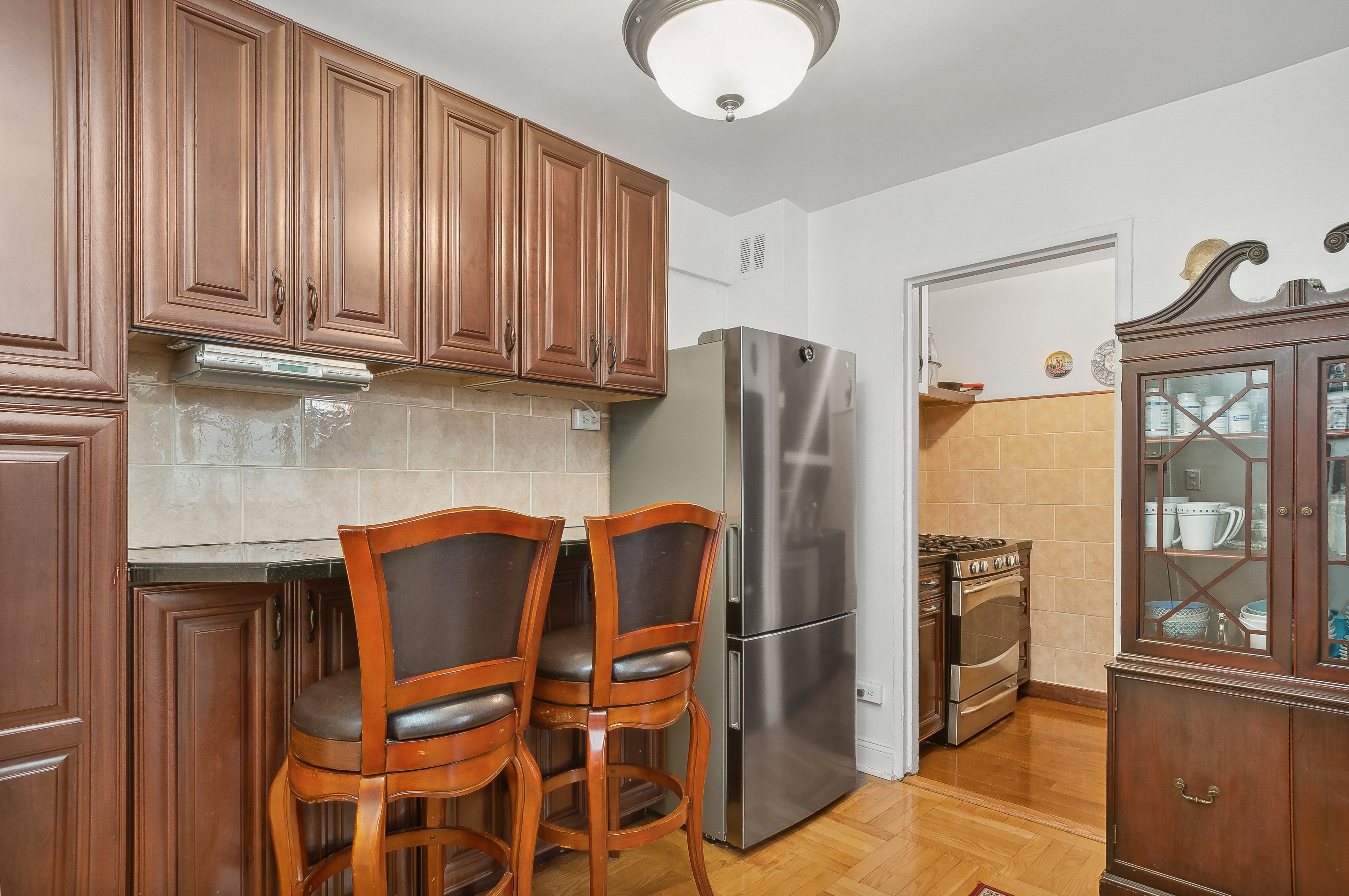 408 West 34th Street, Unit 1F Manhattan, NY 10001 - Photo 5 of 13 a kitchen with stainless steel appliances granite countertop a refrigerator and a stove top oven