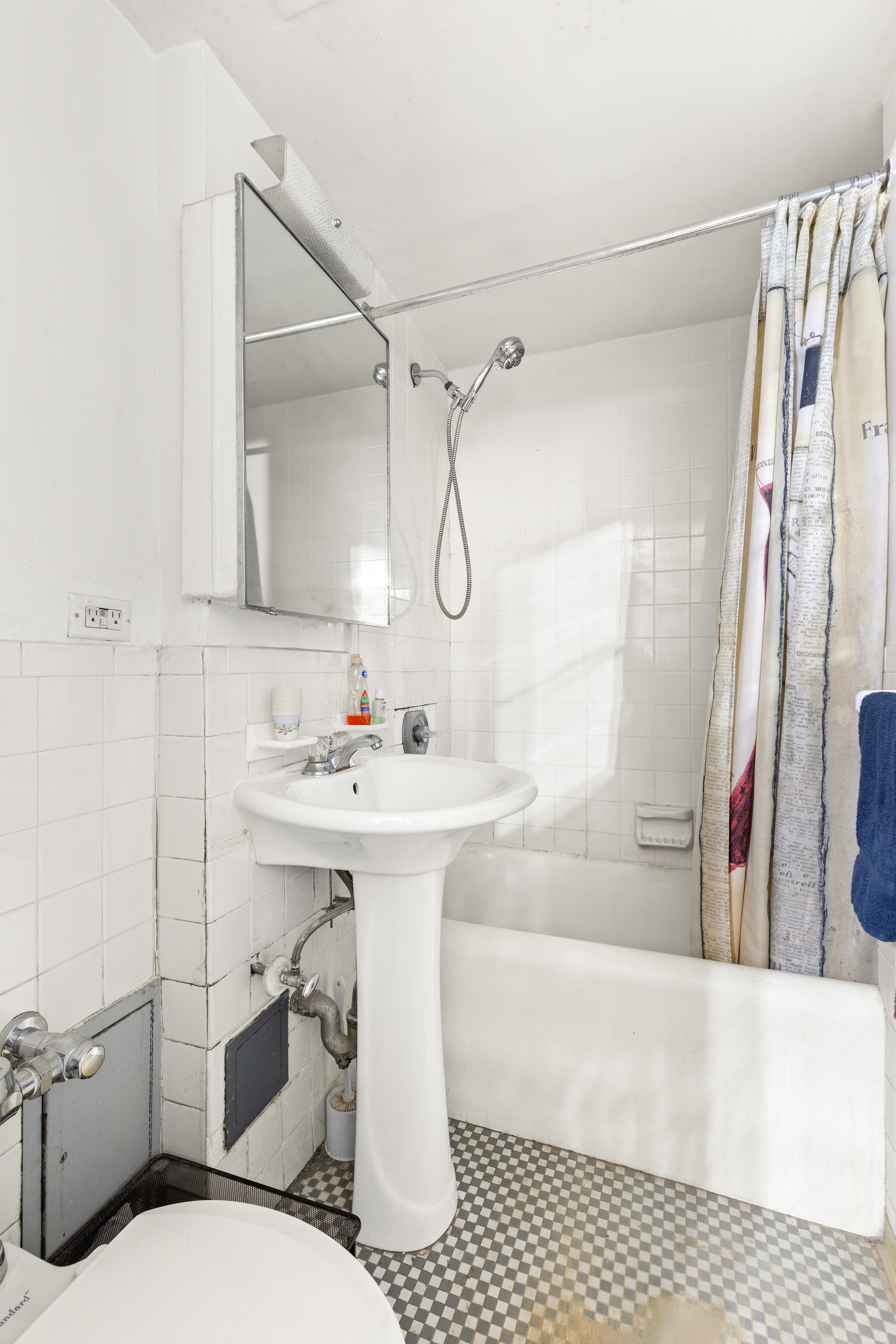 45 Tudor City Place, Unit 716 Manhattan, NY 10017 - Photo 5 of 6 a bathroom with a sink toilet a mirror and shower
