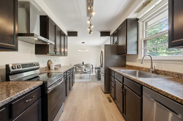 a kitchen with stainless steel appliances granite countertop a sink stove and refrigerator