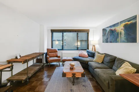 a living room with furniture and a floor to ceiling window