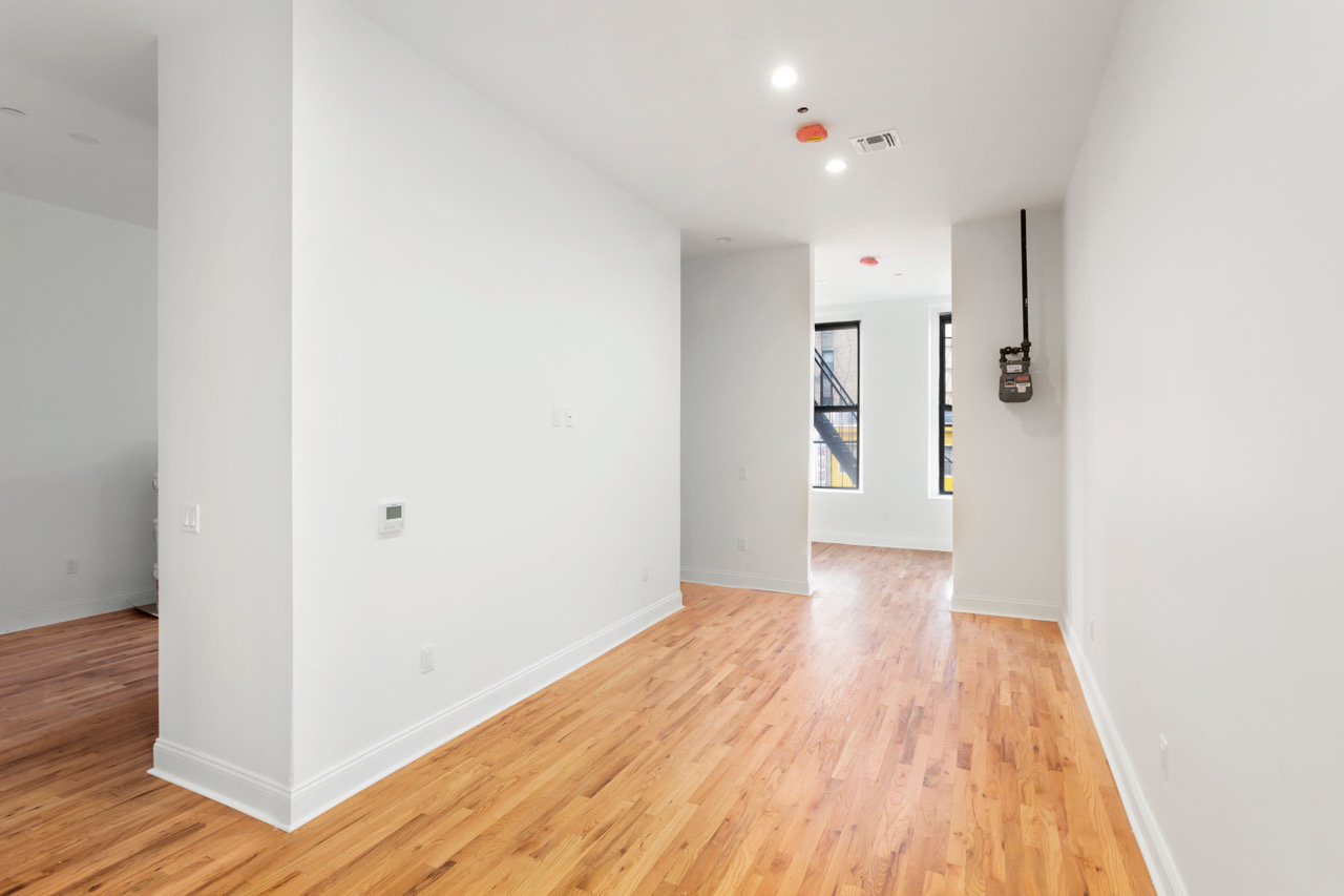281 Grand Street, Unit 2R Manhattan, NY 10002 - Photo 6 of 11 a view of a hallway with wooden floor and closet