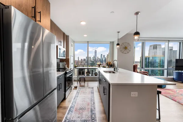 a kitchen with stainless steel appliances granite countertop a refrigerator a sink dishwasher a stove and a refrigerator